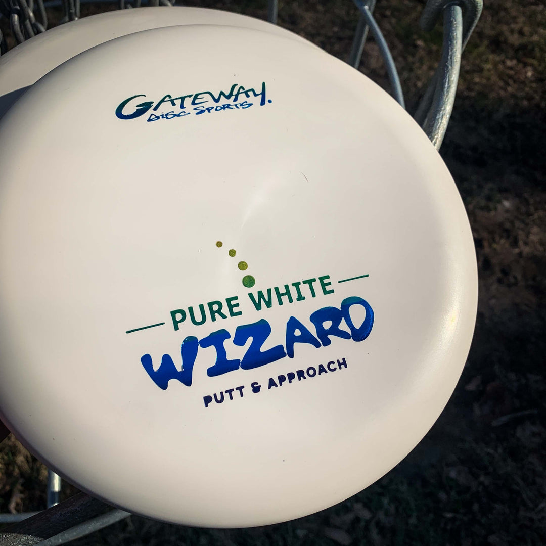 A close-up of the stable workhorse Wizard - Pure White putter in a metal basket outdoors, perfect for confident putts and approaches—even in windy conditions.