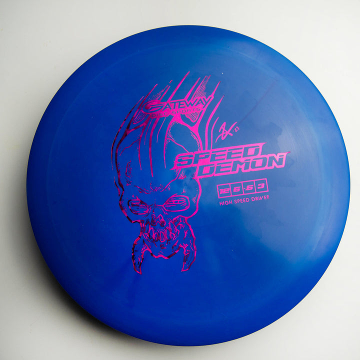 A Cobalt Speed Demon distance driver featuring a blue base and a demonic skull graphic with "Speed Demon" printed in pink on the top surface.