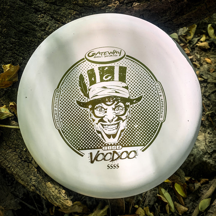 A white Voodoo - Suregrip - SSSS putter from Gateway Disc Sports, featuring a grinning man in a top hat graphic, is ideal for lay-ups and short game play when you're out on the course.