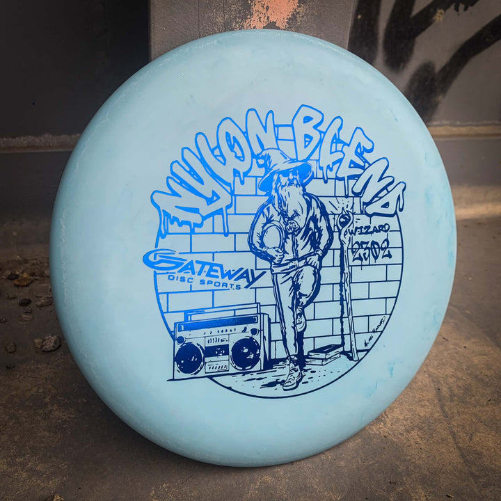 A light blue Wizard - Suregrip Nylon by Gateway Disc Sports, perfect for mid-range drives, features a zombie, brick wall, and boombox on a stable putter design.