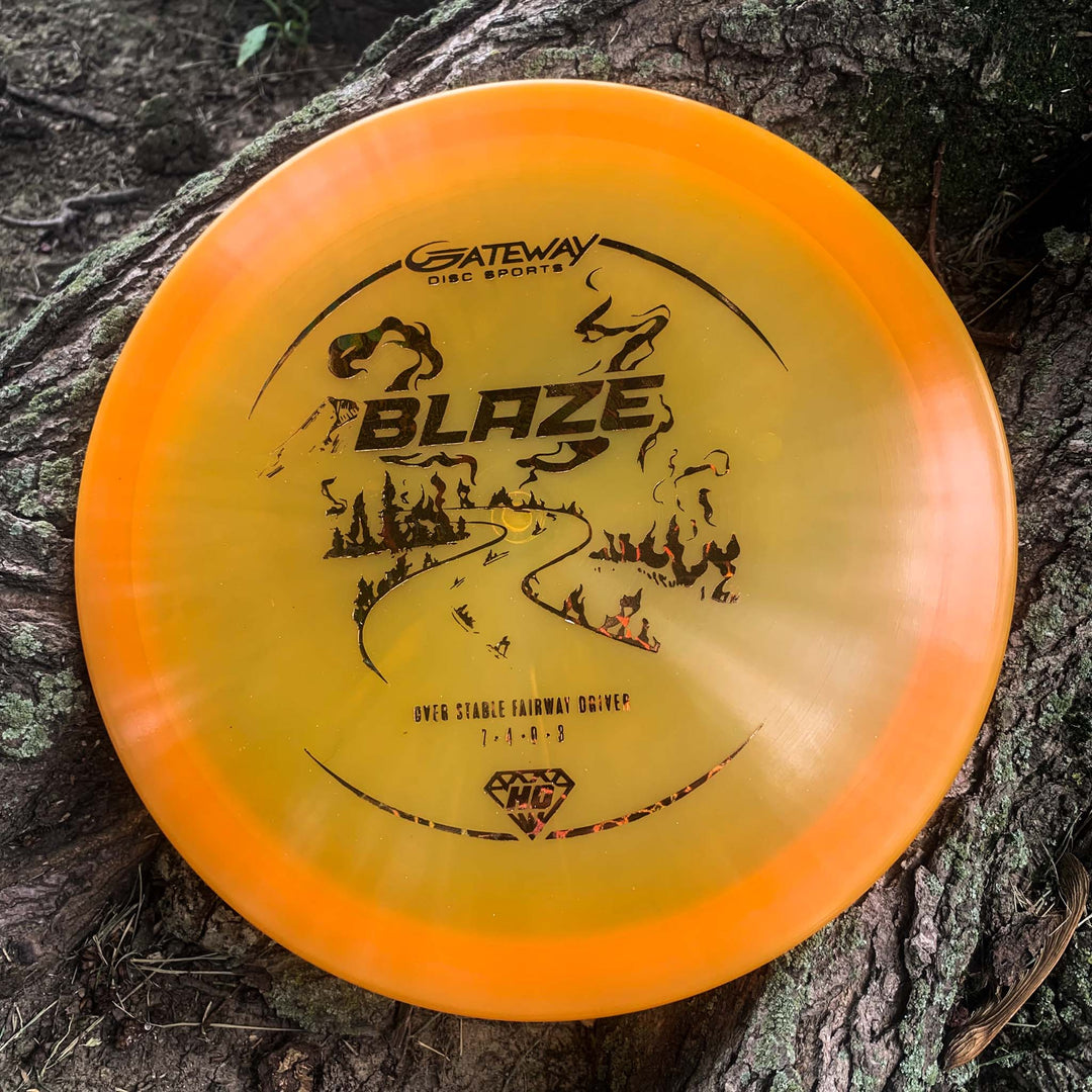 A Blaze - Hyper Diamond (HD) overstable driver rests on a tree trunk, showcasing black artwork and branding—perfect for reliable, predictable drives even in headwinds.