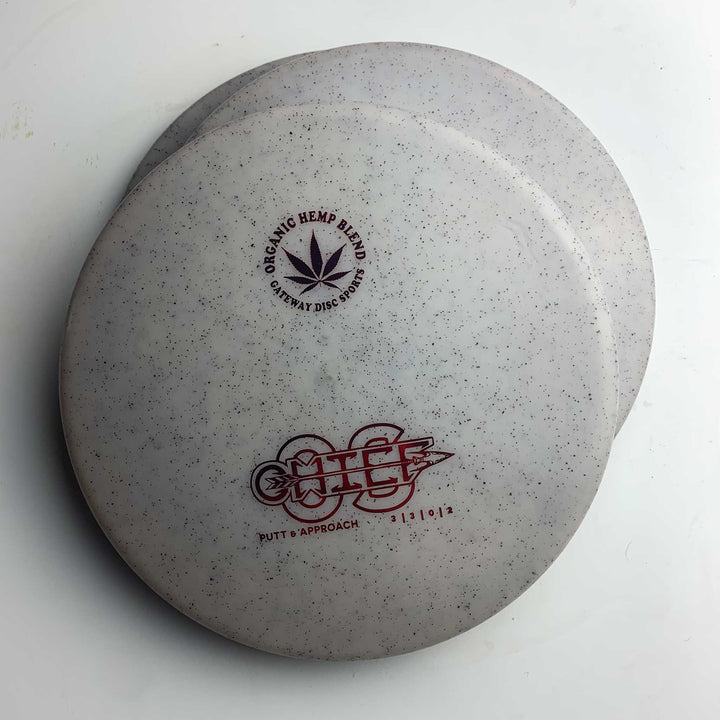 Two white speckled Chief OS - Diamond Hemp disc golf putters are stacked on a white surface; ideal for forehand drives and maintaining a consistent hyzer line with this overstable putter.