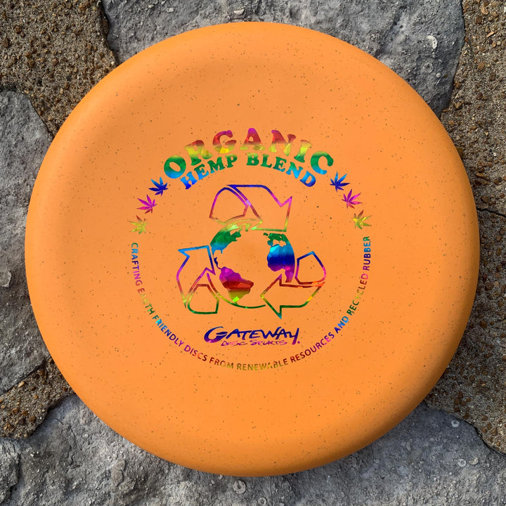 The Magic - Organic Hemp (H-SSS) disc golf putter, featuring a bold recycle symbol and eco-friendly text, rests on stone. Beginner-friendly, it delivers straight-flying performance for all skill levels.