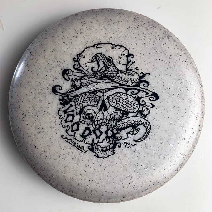 The Voodoo - Diamond Hemp is a white disc golf putter with black speckles, featuring an intricate snake and skull-in-hat design—perfect for fans of distinctive putters.