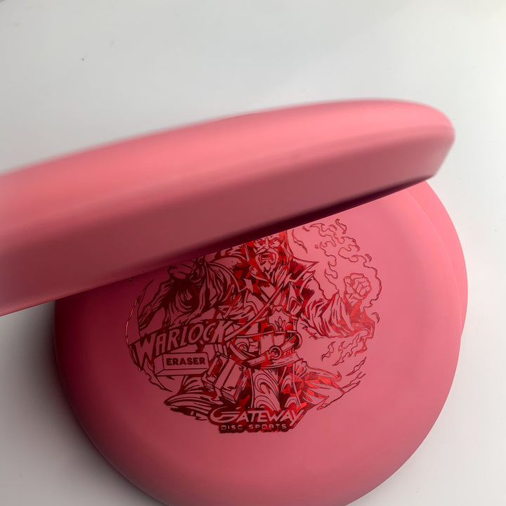 Two pink Warlock - Eraser - Brian Allen disc golf putters stacked, with the top disc partially covering the bottom. The visible disc features a Warlock graphic and Gateway Disc Sports branding.