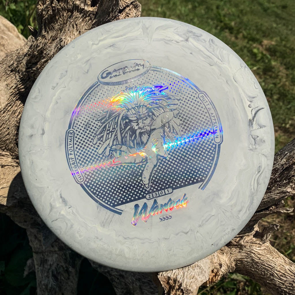 A gray and white marbled Warlock - Suregrip - SSSS disc golf putter with a holographic graphic rests on wood outdoors, ready to enhance your approach game.