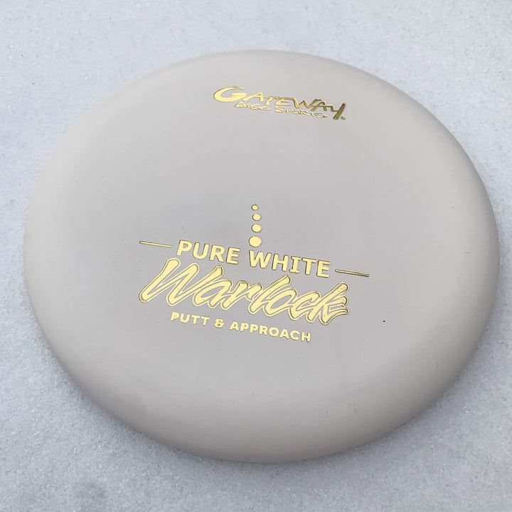 The Warlock - Pure White by Gateway, with gold lettering and marked "Putt & Approach," is displayed on a light surface€”ideal for fans of the Warlock or Wizard series.