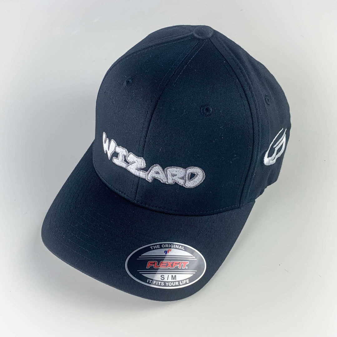 The Wizard Flexfit Fitted Hat features "WIZARD" embroidered in white on the front, a Wizard bar stamp on the side, and offers a comfortable fit—perfect for any Mini-Wizard enthusiast.
